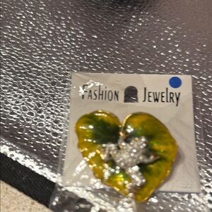 Vintage mGold and Green Leaf Brooch with a Silver frog sitting on it